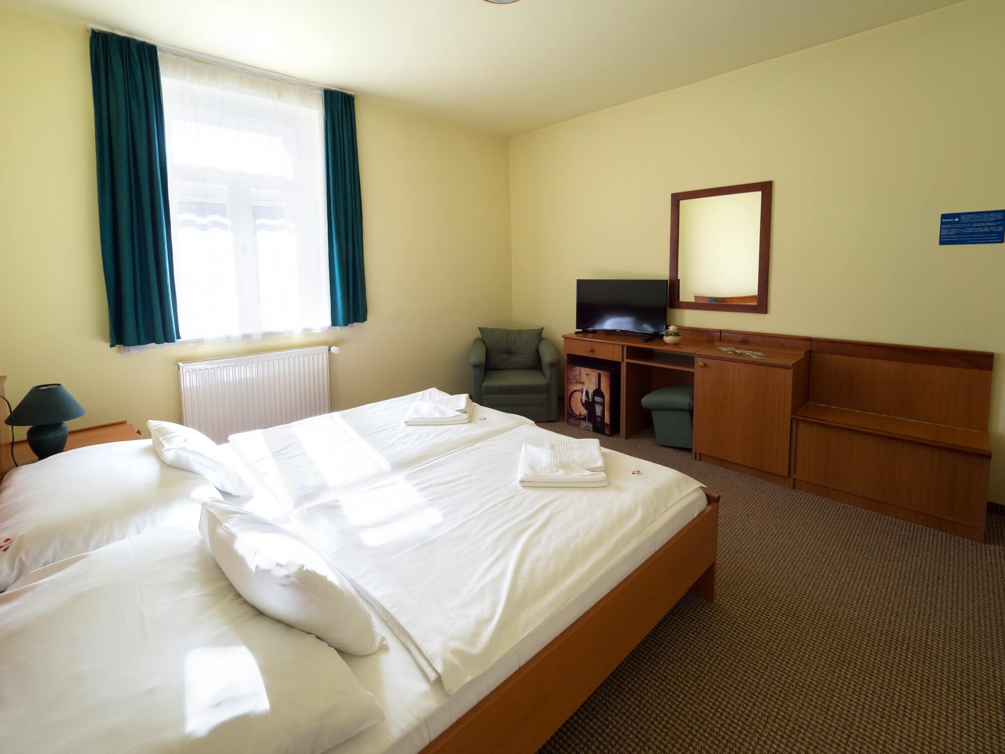Hotel Cabernet Villánykövesd standard kétágyas szobája tévével, fotellal