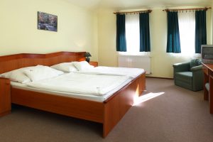 A Hotel Cabernet standard kétágyas szobája, a képen dupla ágy, tévé, íróasztal, fotel