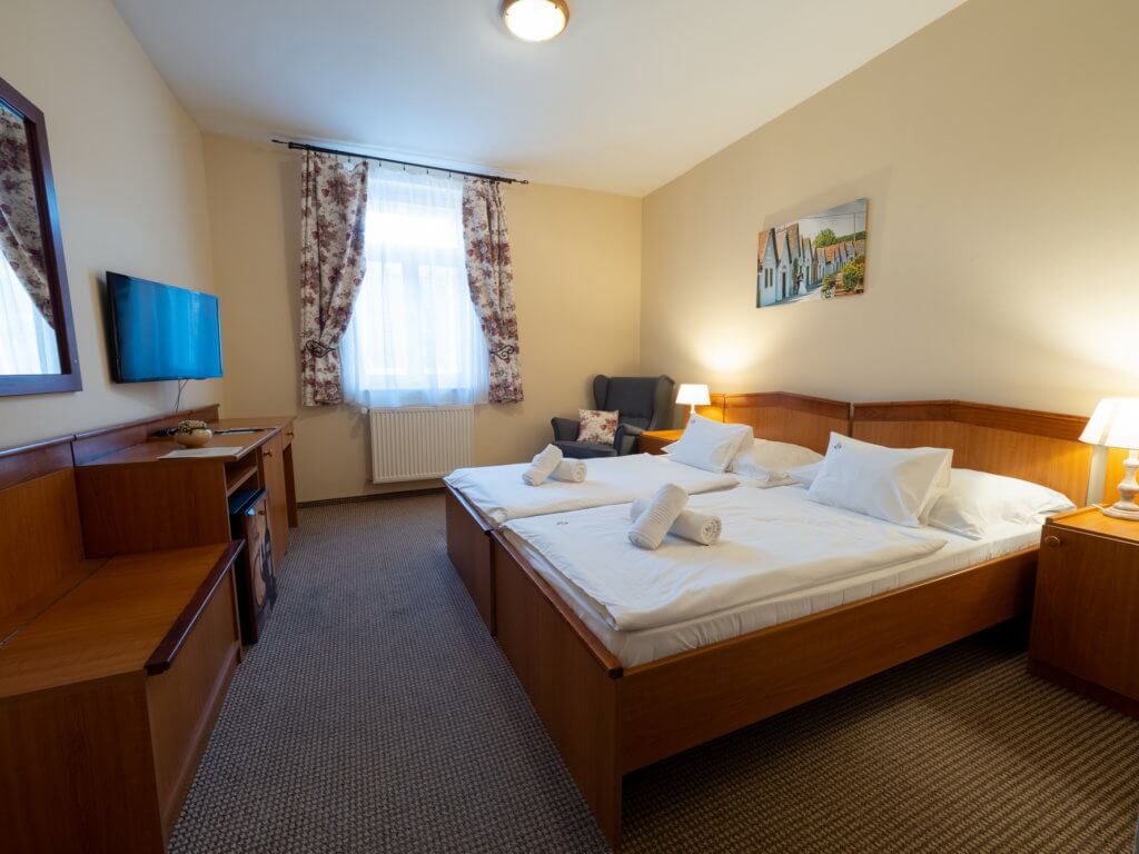 A Hotel Cabernet standard kétágyas szobája, a képen egy dupla ágy, tévé, íróasztal, fotel